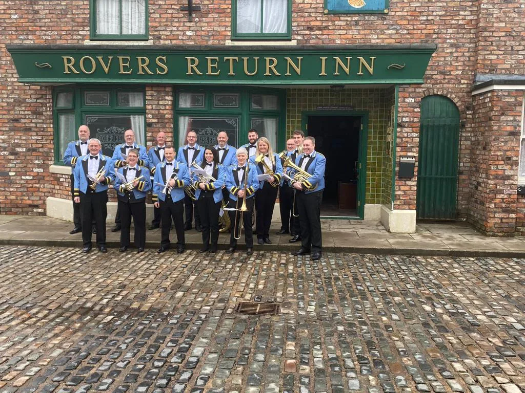 Fairey Band players outside the Rovers Return on the Coronation Street set
